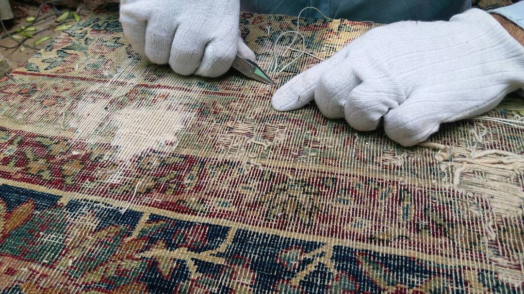 Tapis ancien au velours disparu : chaîne et trame à nu, examinées avant retissage
