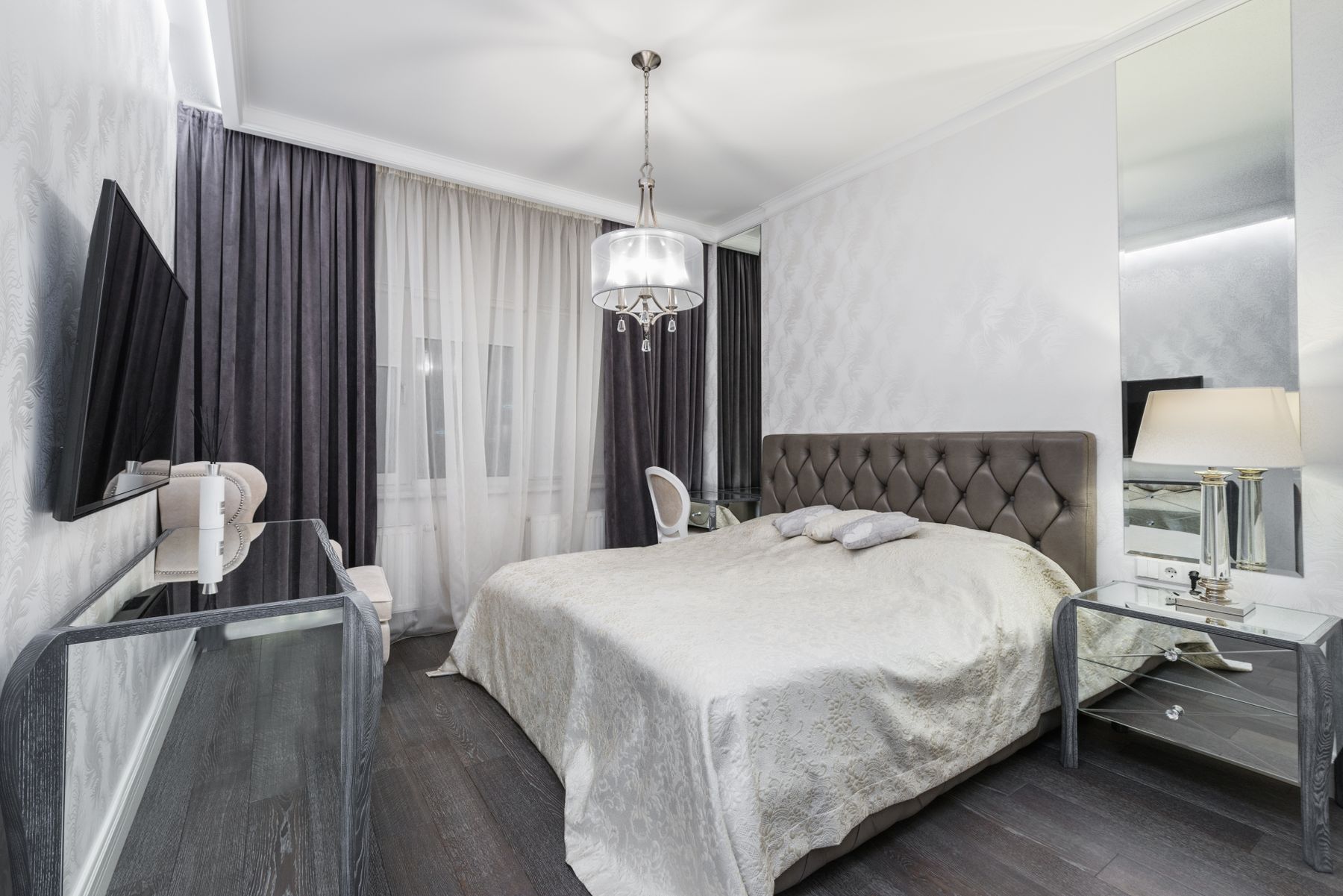 Chambre installée, lit à tête capitonnée et rideaux posés
