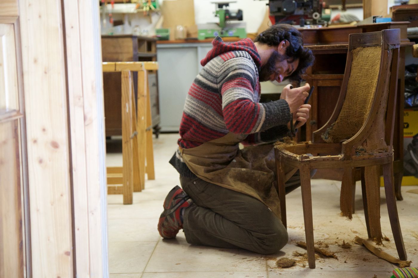 Artisan préparant le cadre en bois d'une chaise en atelier