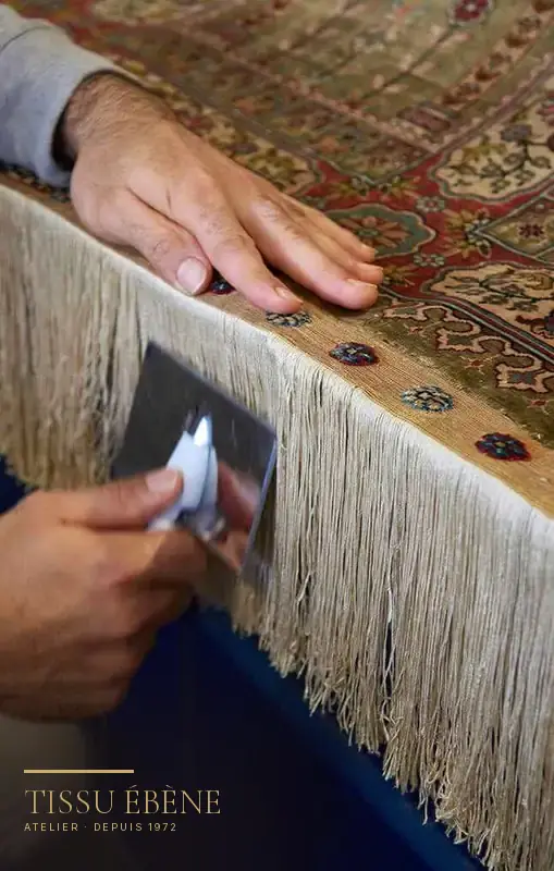 Réparation de tapis : reprise à la main de la frange et de la lisière d&rsquo;un tapis persan à l&rsquo;atelier