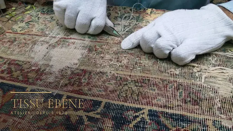 Tapis ancien usé jusqu&rsquo;à la trame, pris en charge pour restauration à l&rsquo;atelier