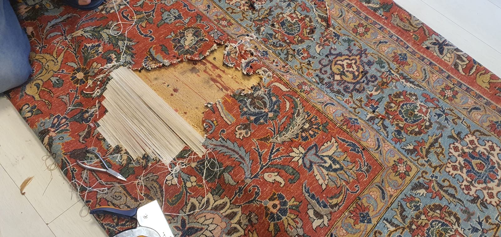 Reconstruction de la fondation d&rsquo;un tapis&nbsp;: fils de chaîne neufs retendus en travers de la lacune, à l&rsquo;atelier