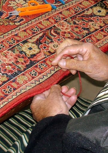 Réparation de bordure de tapis : le cordon de lisière retissé au fil, à la main